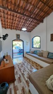 a living room with two beds and a wooden floor at Sitio Serra e Mar in Saquarema
