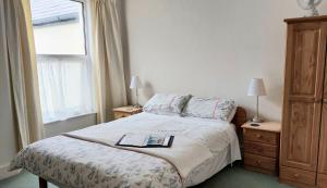 a bedroom with a bed with a book on it at Trelawney Guest House Room only in Falmouth