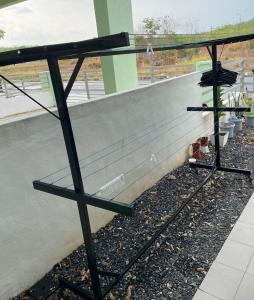 a metal bench sitting next to a wall at Rumah Homestay in Kangar