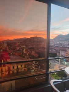 a view of a city at sunset from a building at Vive el esplendor del Centro Histórico in Quito
