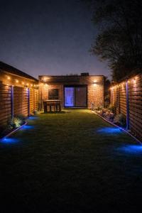 a brick house with lights on it at night at Love Room 85 avec Jacuzzi & Terrasse Privé in Kortrijk
