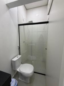 a bathroom with a toilet and a glass shower at Loft bem localizado na cidade! in Boa Vista