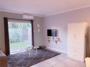 a living room with a table and a window at Clifton Home in Richards Bay