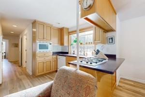a kitchen with wooden cabinets and a stove top oven at Dog-Friendly Sunriver condo with deck bikes in Sunriver