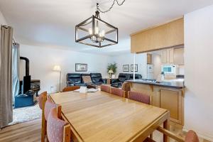 a dining room and living room with a wooden table at Dog-Friendly Sunriver condo with deck bikes in Sunriver