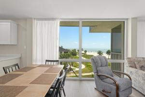 a dining room with a table and a view of the ocean at Island Beach Club #P3E in Ybel