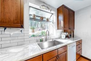 a kitchen with a sink and a window at Ski getaway with amazing mountain views fireplace pool & river path access in Olympic Valley