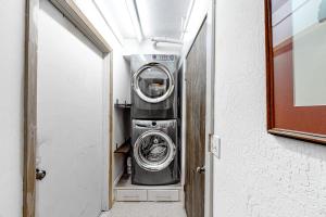 a washer and dryer in a small room at Ski getaway with amazing mountain views fireplace pool & river path access in Olympic Valley +27 photos