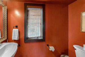 an orange bathroom with a sink and a window at Ski getaway with amazing mountain views fireplace pool & river path access in Olympic Valley