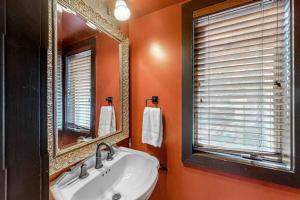 an orange bathroom with a sink and a mirror at Ski getaway with amazing mountain views fireplace pool & river path access in Olympic Valley