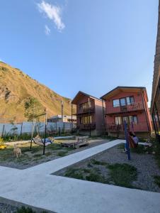 a playground with swings and a house and a hill at Cottage nikolozi2 in Arsha