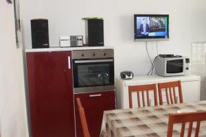 a kitchen with a red refrigerator and a microwave at The Sea House Jaz in Preko