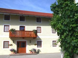 a building with a balcony on the side of it at Pension Poschmühle in Traunreut