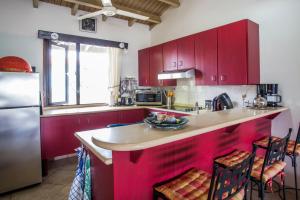 a kitchen with red cabinets and a counter top at Cozy Bungalow in the Tropical Gardens of Blue Bay in Blue Bay
