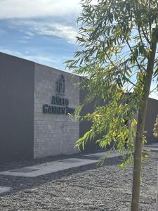 a building with a sign on the side of it at Añelo Garden Inn in Añelo