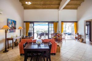 a living room with a couch and a table at Cozy Bungalow in the Tropical Gardens of Blue Bay in Blue Bay