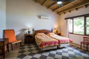 a bedroom with a bed and a desk and a window at Cozy Bungalow in the Tropical Gardens of Blue Bay in Blue Bay +68 photos