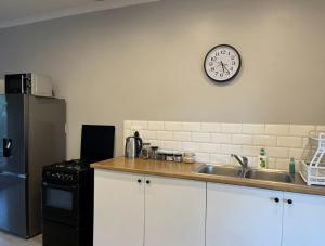a kitchen with a sink and a clock on the wall at Clifton Home in Richards Bay