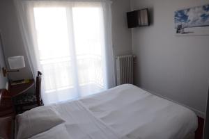 a bedroom with a white bed and a window at Logis Le Petit Trianon in Saint-Brevin-les-Pins