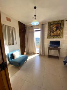 a living room with a blue couch and a window at Ta’ Giljan B&B Gozo in Xagħra +45 photos