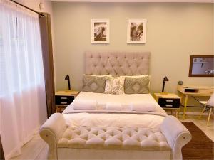 a bedroom with a large bed with a tufted headboard at Clifton Home in Richards Bay