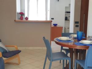 a dining room with a wooden table and blue chairs at La Finestra sui Tigli in Mandello del Lario