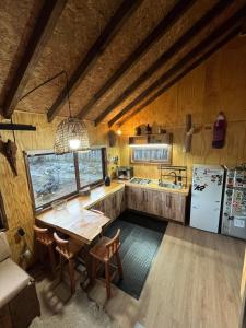 a kitchen with a wooden table and a refrigerator at CasaAndina in Malalcahuello