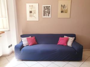 a blue couch with pink and white pillows on it at La Finestra sui Tigli in Mandello del Lario