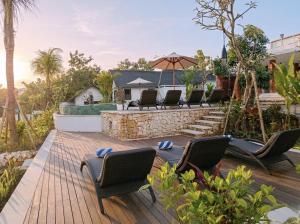 a backyard deck with chairs and a table at Sardja Uluwatu in Uluwatu