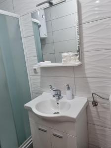 a bathroom with a sink and a mirror at Apartman Savic 1 Centar in Bijeljina +22 photos