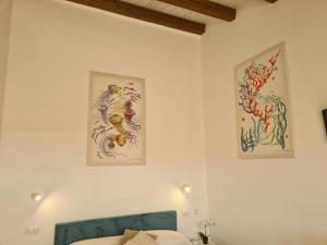 a bedroom with two paintings on the wall at Antò 2.0 in Castellammare del Golfo