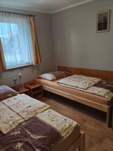 a bedroom with two beds and a window at Zajazd U Doktora in Lubrza