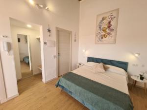 a bedroom with a bed with a blue head board at Antò 2.0 in Castellammare del Golfo