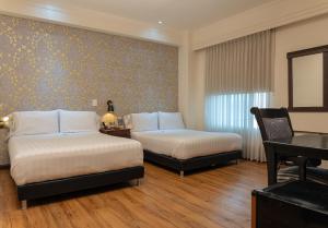 a hotel room with two beds and a piano at Hotel Castilla Real in Pereira