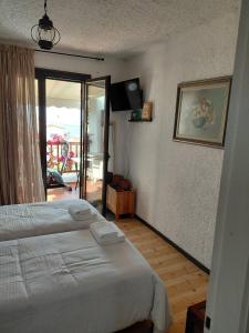 a bedroom with a bed and a view of a patio at Theano apartment in Argos