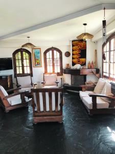 a living room with couches and tables and windows at Brisas Hosteria in Santa Clara del Mar