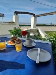 a table with a blue table cloth with a plate of food at Brisas Hosteria in Santa Clara del Mar