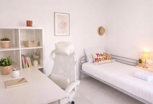 a white living room with a couch and a chair at Maison prairie en fleurs in Le Perray-en-Yvelines