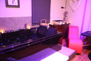 a bath tub in a room with two pink chairs at Secret Balnéo in Floirac