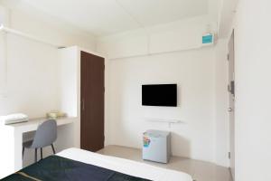 a bedroom with a bed and a desk and a tv at Dancenter Rq Suvarnabhumi Airport in Bangkok