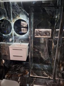 a bathroom with a black marble wall with a sink at Apartament Premium Tarnów 2 in Tarnów +10 photos