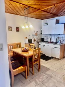 a kitchen with a wooden table and wooden ceilings at Ferienwohnung Theisen in Bernkastel-Kues