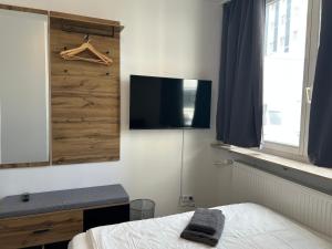 a bedroom with a bed and a tv on a wall at Noble Rooms Saarbrücken in Saarbrücken