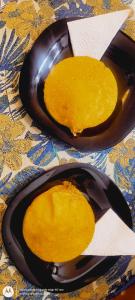 two black plates with yellow food on a table at Hostal Casa de las Americas in Cartagena de Indias +15 photos