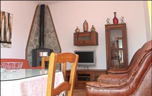 sala de estar con mesa, sillas y TV en Chalet Vigía 113, en Conil de la Frontera