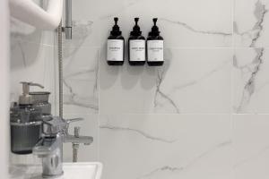 three bottles of wine on a wall in a bathroom at AC Vienibas Square apartments in Daugavpils