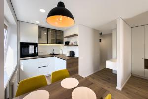 a kitchen and dining room with a table and chairs at AC Vienibas Square apartments in Daugavpils +17 photos