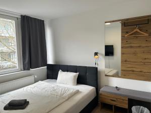 a bedroom with a bed and a window and a mirror at Noble Rooms Saarbrücken in Saarbrücken