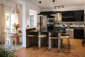 a kitchen with a large island with bar stools at Villa Oasys in Almería