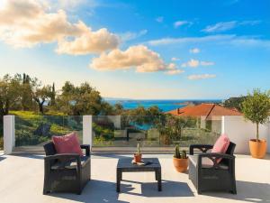 a patio with two chairs and a table at Villa Anafoufou Afionas with private heatable pool in Afionas